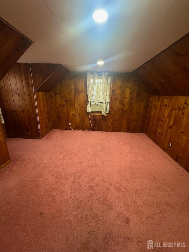 bonus room featuring wood walls, carpet flooring, lofted ceiling, and cooling unit