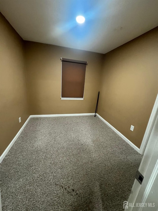 carpeted empty room with baseboards