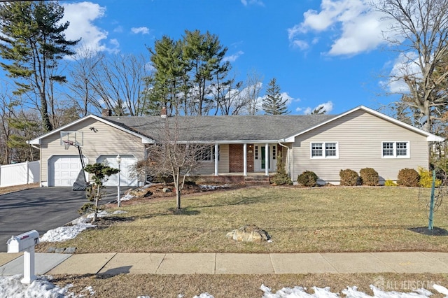 ranch-style home with aphalt driveway, a garage, covered porch, fence, and a front lawn