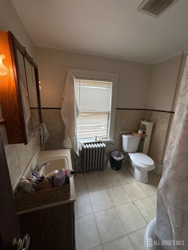 bathroom featuring radiator heating unit, tile patterned floors, and toilet