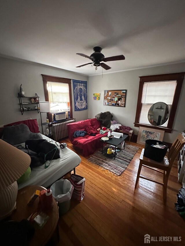 living room featuring radiator heating unit, wood-type flooring, and ceiling fan