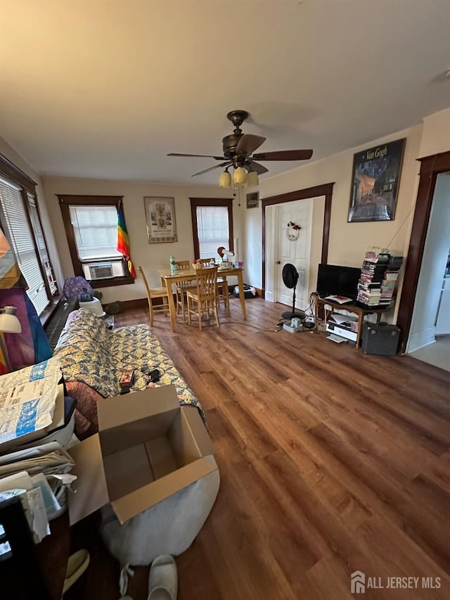 living room with cooling unit, ceiling fan, and wood-type flooring