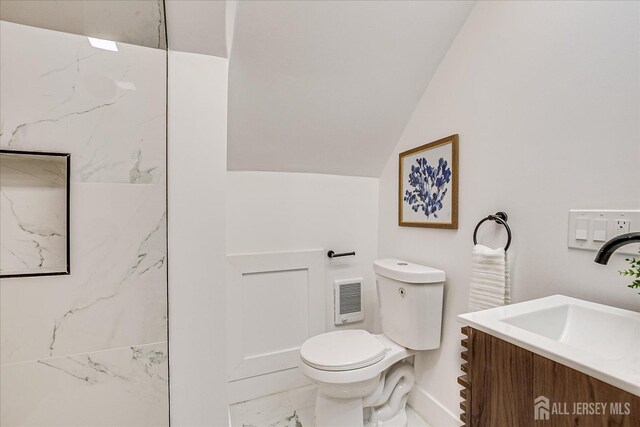 bathroom featuring toilet, vanity, and lofted ceiling