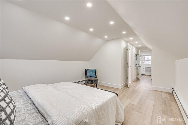 bedroom featuring baseboard heating, vaulted ceiling, and light hardwood / wood-style flooring