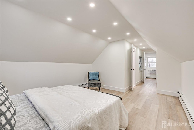 bedroom featuring vaulted ceiling, a baseboard heating unit, and light hardwood / wood-style floors