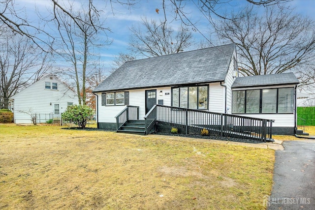 view of front of home featuring a sunroom, a wooden deck, and a front yard