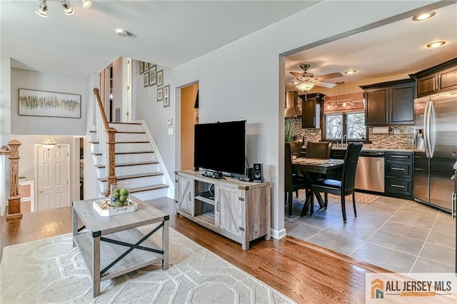 35 Outcalt Rd, Edison, NJ 08817 - living area featuring light wood-type flooring, baseboards, ceiling fan, and stairway