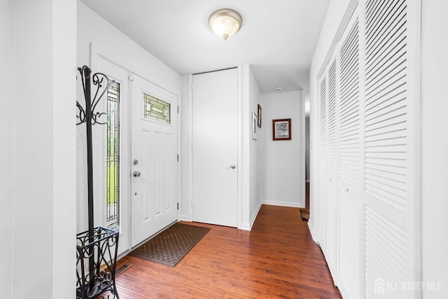foyer with baseboards and wood finished floors