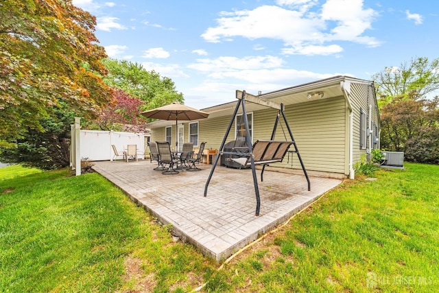 rear view of house featuring a yard, fence, a patio, and central AC