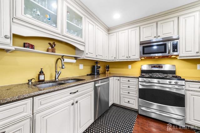 kitchen featuring a sink, stainless steel appliances, white cabinetry, and stone counters