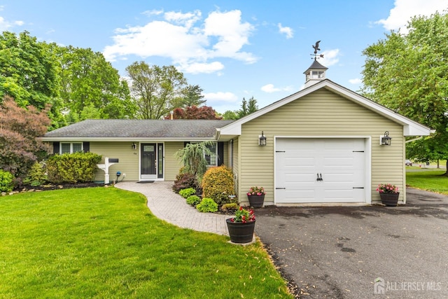 ranch-style house featuring a front lawn, driveway, and an attached garage