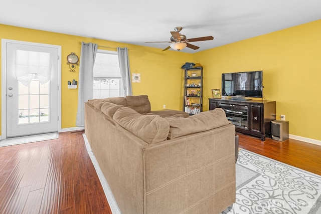living area with wood finished floors, baseboards, and ceiling fan