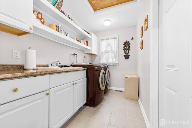laundry area featuring light tile patterned floors, a sink, cabinet space, washing machine and clothes dryer, and baseboards