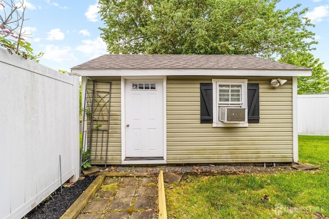 view of outbuilding featuring cooling unit, an outdoor structure, and fence
