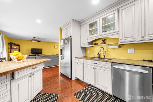 kitchen with a ceiling fan, butcher block countertops, a sink, white cabinets, and appliances with stainless steel finishes