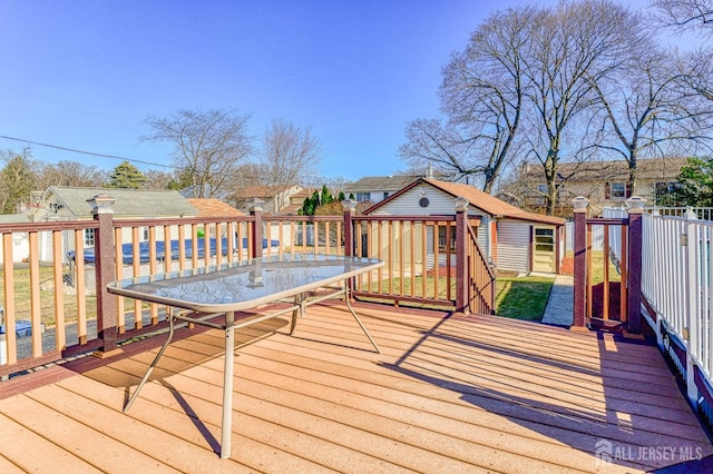 wooden deck with an outdoor structure and a residential view