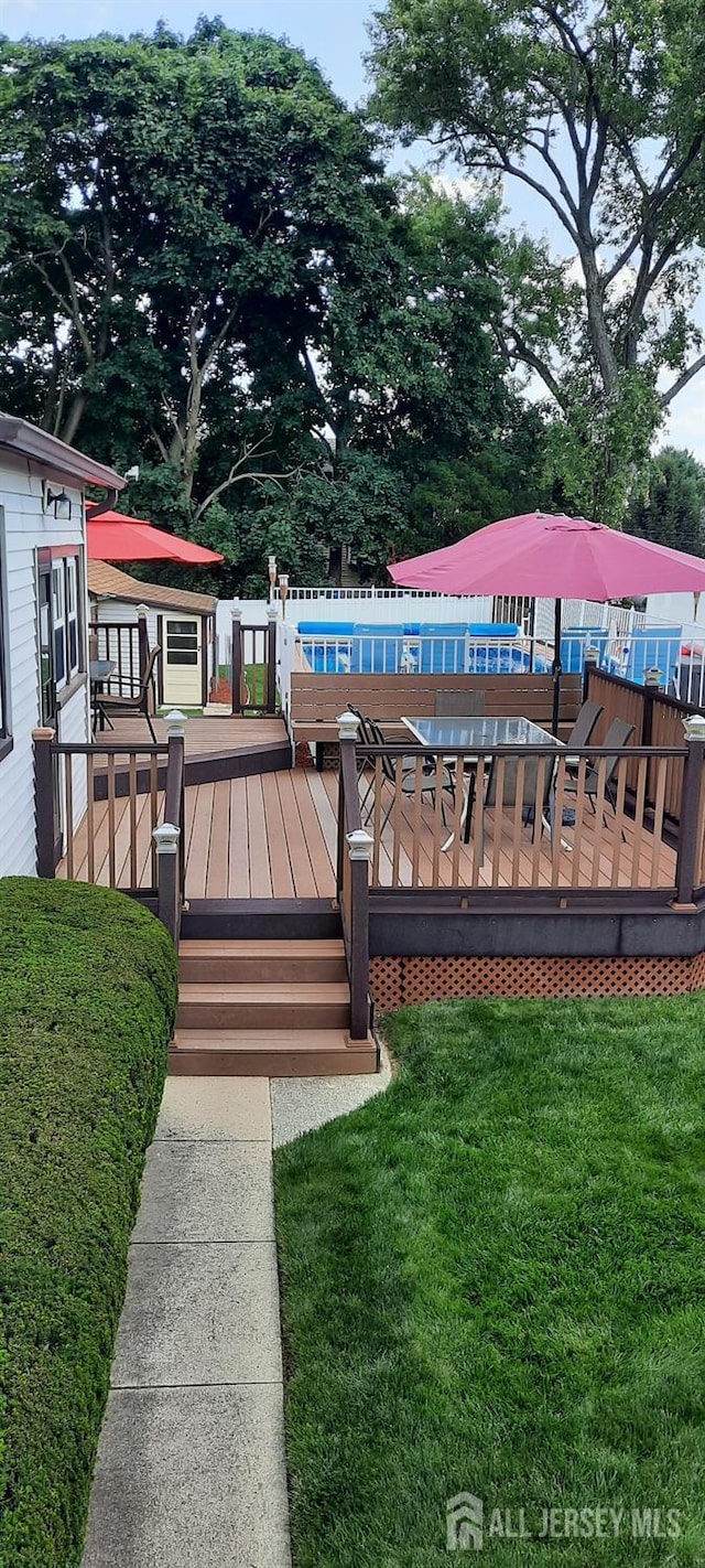 wooden deck featuring a yard