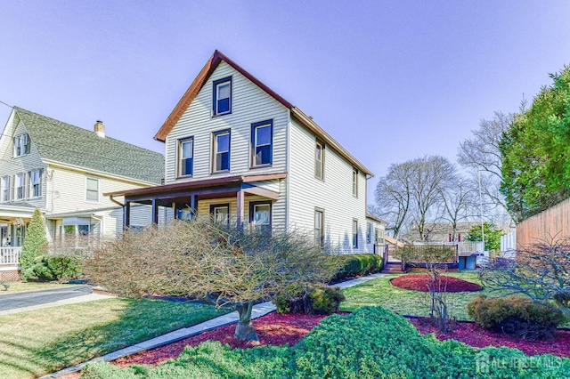 view of front of house with a front yard and fence