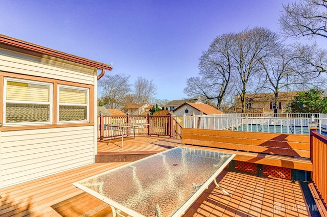 deck featuring a swimming pool and fence