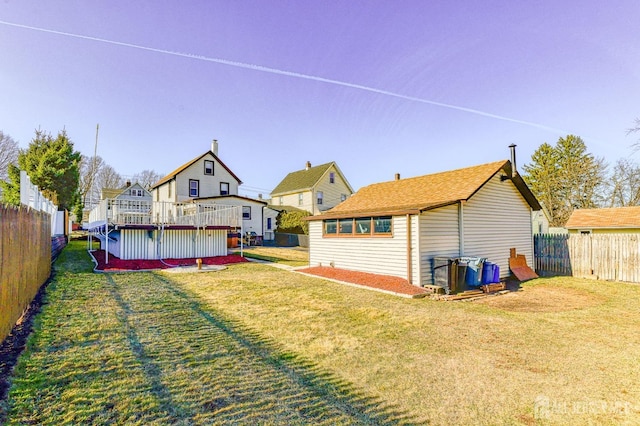 back of property featuring a yard and a fenced backyard