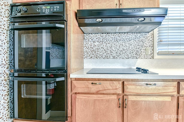 kitchen with backsplash, black appliances, light countertops, and exhaust hood