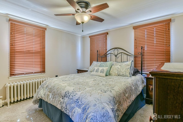 bedroom featuring crown molding, radiator heating unit, a ceiling fan, and carpet floors