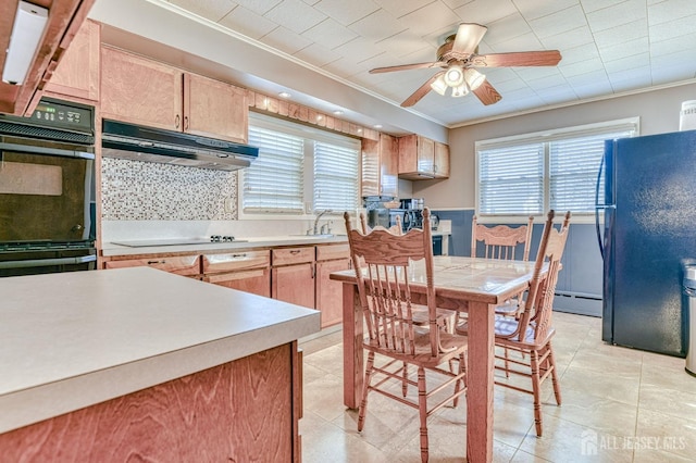 kitchen featuring black appliances, ornamental molding, light brown cabinets, under cabinet range hood, and a sink