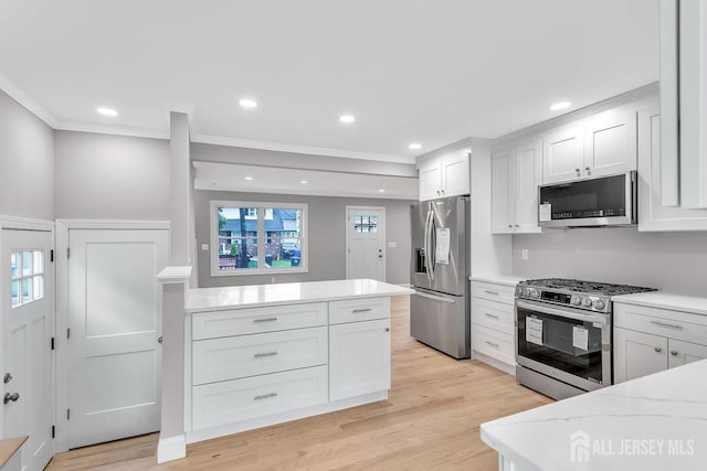 64 2nd Ave, Port Reading, NJ 07064 - kitchen with appliances with stainless steel finishes, crown molding, light wood-style flooring, white cabinets, and light stone countertops