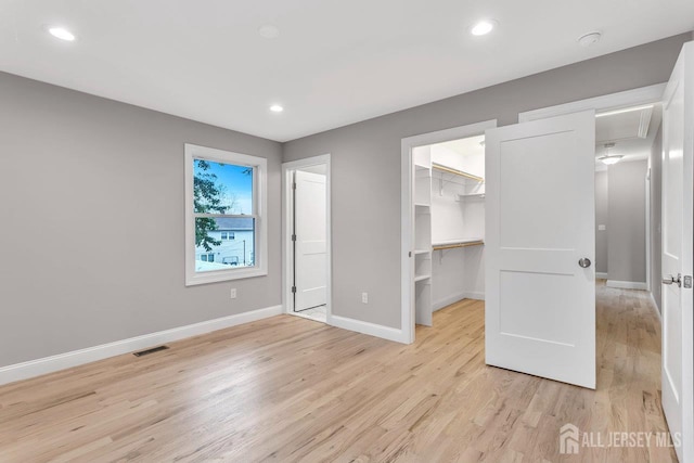 64 2nd Ave, Port Reading, NJ 07064 - unfurnished bedroom with light wood-style flooring, a walk in closet, a closet, recessed lighting, and attic access