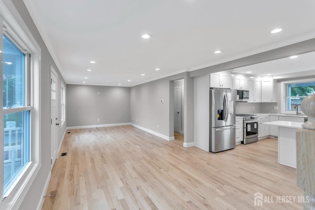 64 2nd Ave, Port Reading, NJ 07064 - kitchen featuring stainless steel appliances, light countertops, baseboards, crown molding, and white cabinets