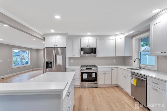 64 2nd Ave, Port Reading, NJ 07064 - kitchen with stainless steel appliances, a sink, light wood finished floors, healthy amount of natural light, and ornamental molding