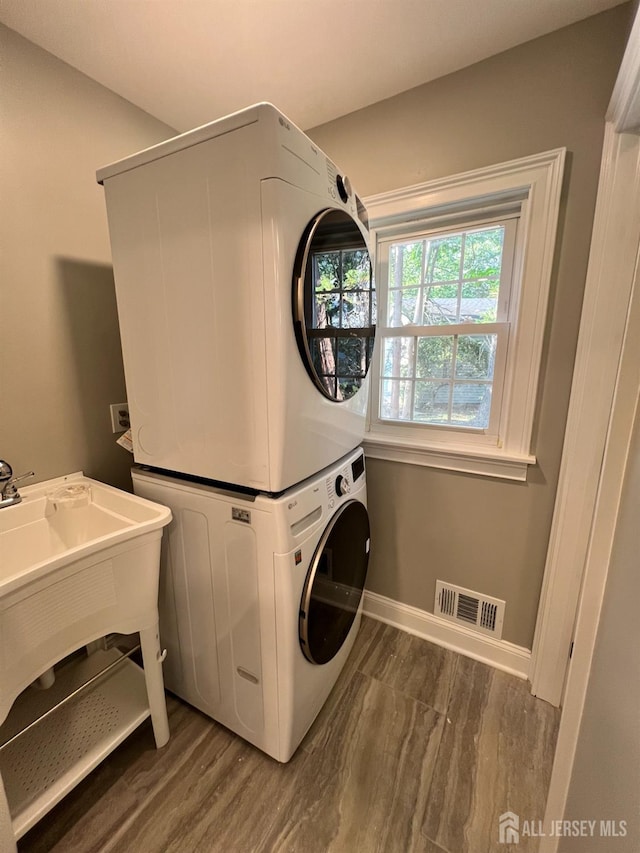 washroom with stacked washing maching and dryer