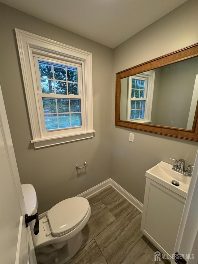 bathroom with vanity, toilet, and a wealth of natural light