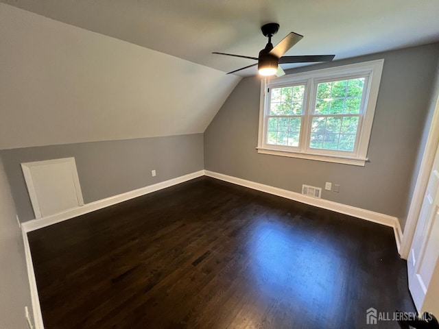 additional living space with ceiling fan, dark hardwood / wood-style flooring, and vaulted ceiling