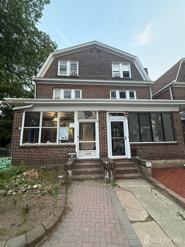 69 Lewis St, Perth Amboy, NJ 08861 - view of front of property with entry steps, brick siding, and a gambrel roof