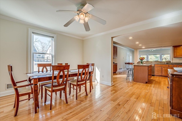 dining area with ceiling fan, light wood-type flooring, baseboards, and ornamental molding