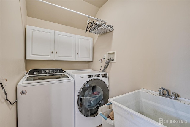 clothes washing area with cabinet space, independent washer and dryer, and a sink