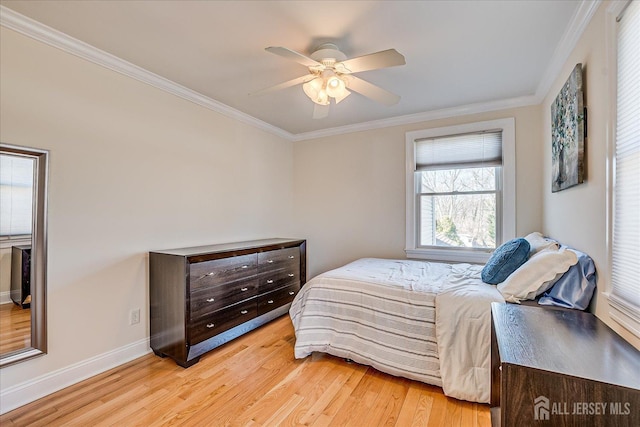 bedroom with a ceiling fan, crown molding, light wood-style floors, and baseboards