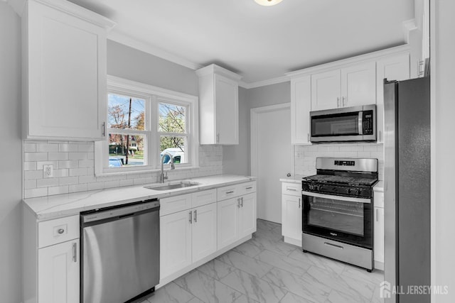 kitchen with stainless steel appliances, a sink, light marble finish flooring, light stone counters, and white cabinets