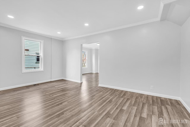 unfurnished room featuring wood finished floors, crown molding, baseboards, and recessed lighting