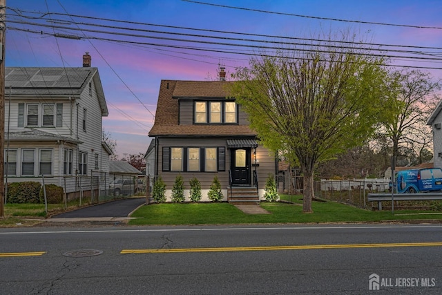 view of front of home with asphalt driveway and a shingled roof