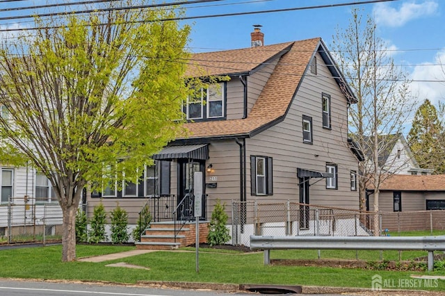 view of front facade with a shingled roof and a chimney