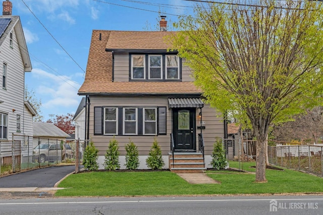 view of front of property with roof with shingles and a chimney