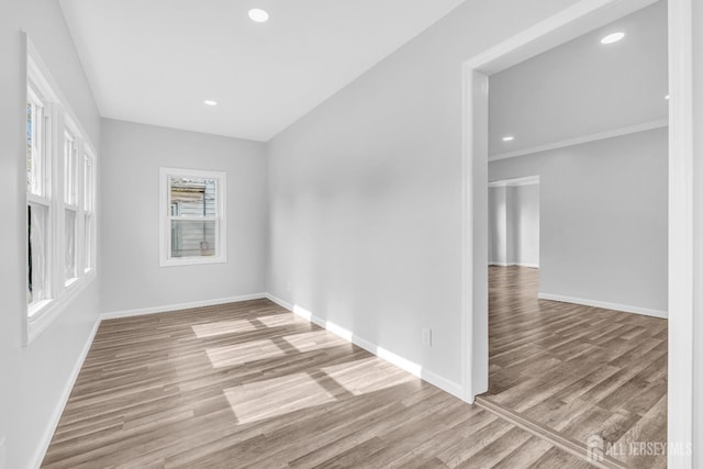 empty room featuring wood finished floors, baseboards, and recessed lighting