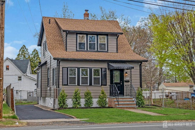 view of front of home with a chimney and a shingled roof