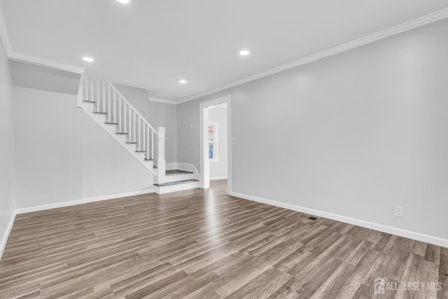 unfurnished living room with stairway, wood finished floors, recessed lighting, baseboards, and ornamental molding
