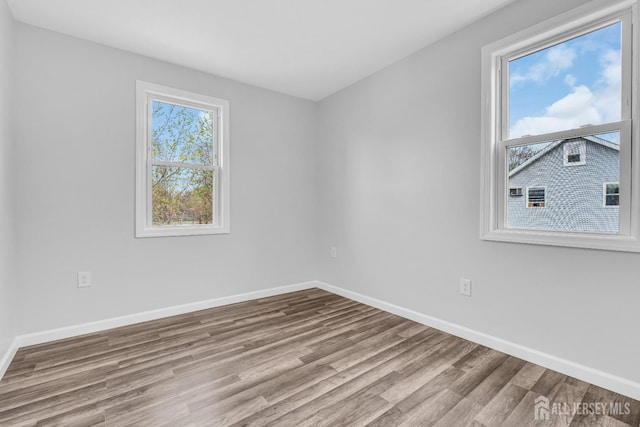 unfurnished room featuring wood finished floors and baseboards