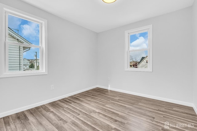 unfurnished room featuring wood finished floors and baseboards