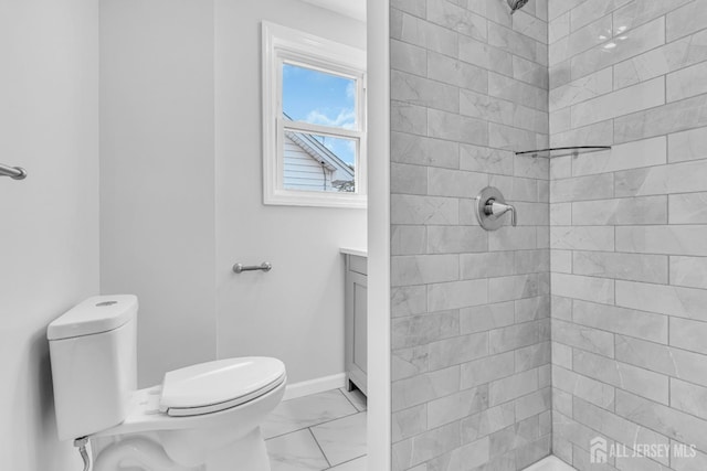 full bathroom featuring marble look tile flooring, toilet, a tile shower, vanity, and baseboards