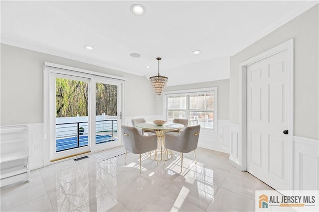 dining area with ornamental molding, a wealth of natural light, and an inviting chandelier